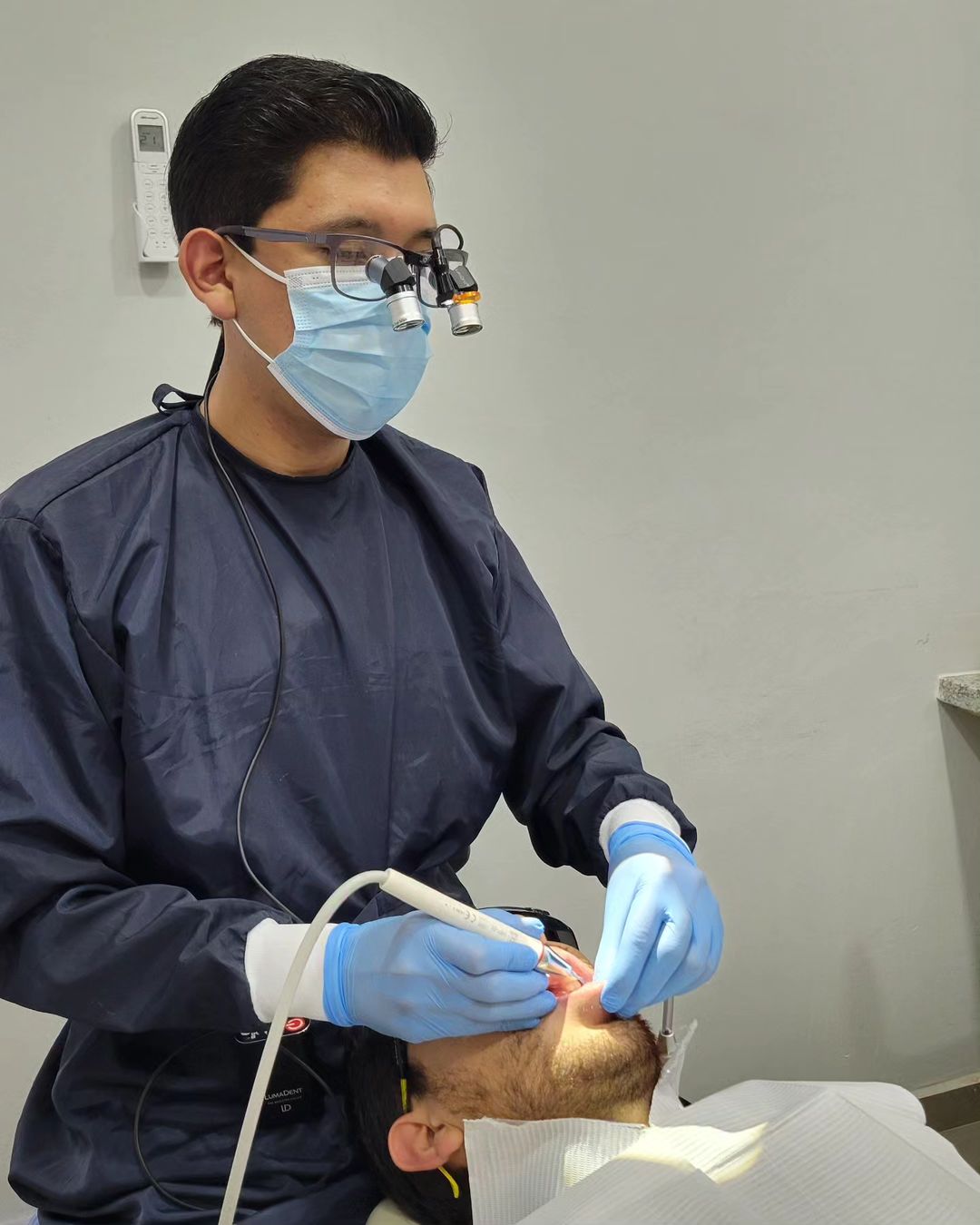 Dentists performing work on patients with LumaDent Ergo Loupes.