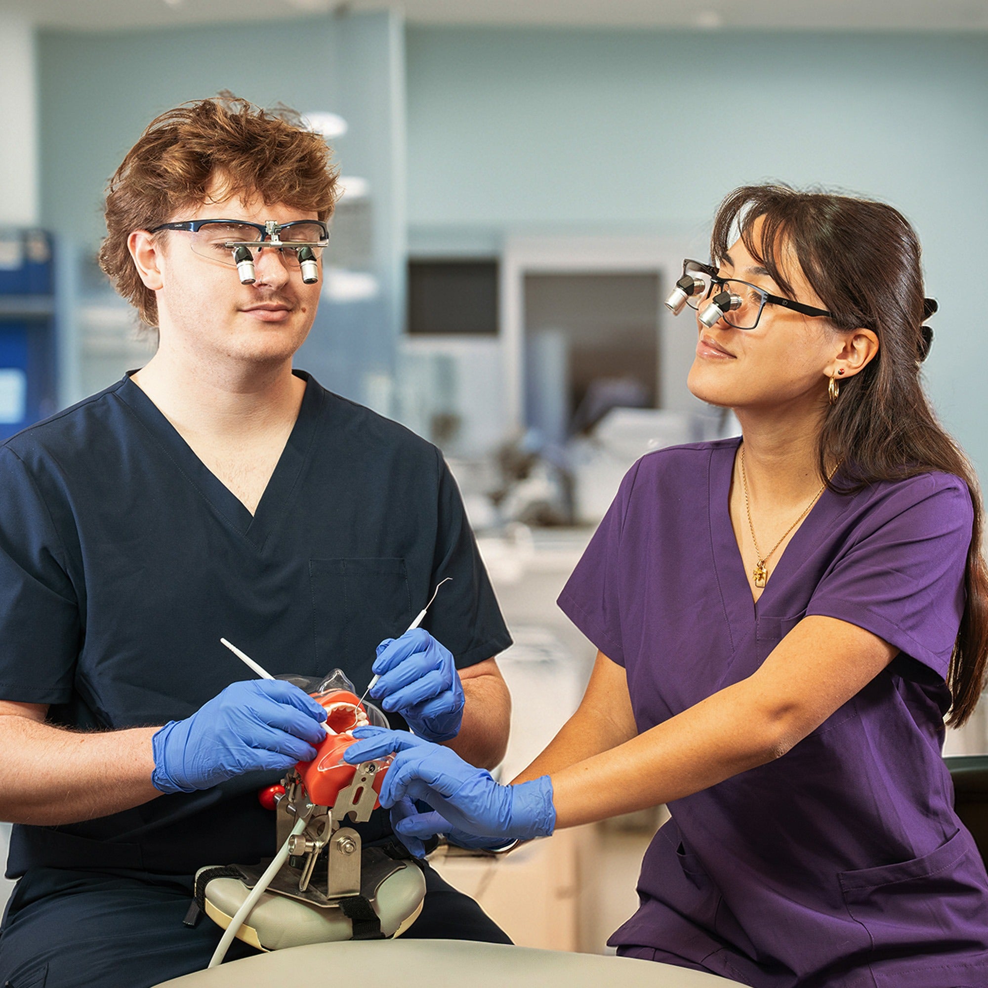 Student wearing LumaDent loupes, showcasing the ergonomic design and professional use in a clinical environment.
