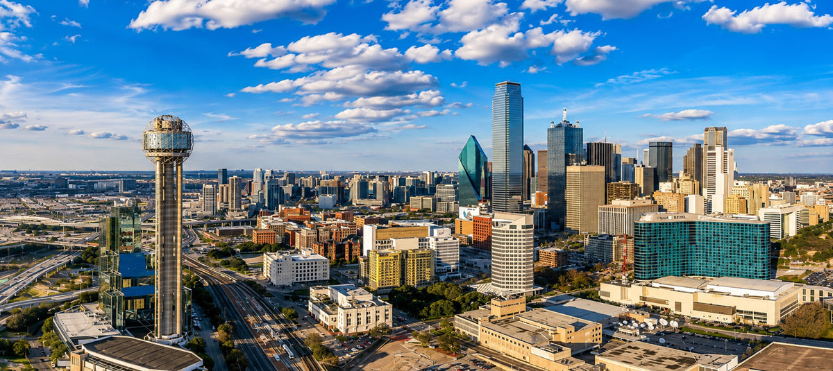 Panoramic daytime aerial view of the Downtown Dallas, Texas skyline featuring Reunion Tower